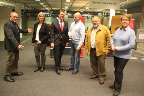 Zum Foto: Platz genug, will Lothar Tarnow (links) sagen. Neben den zahlreichen Musikern und Sängern finden 420 Zuhörer in der zum Konzertsaal umfunktionierten Sparkasse Platz. Das  Konzert planten weiter: Susanne Sundhoff, Orchester Vahlhausen Lippe Detmold, Arnd Paas, Vorstandsmitglied der Sparkasse Paderborn-Detmold, Heinz Holey, Oberst der Schützengesellschaft, Moderator  Hans-Dieter Buckoh und Elisabeth Stückemann, Detmolder Tafel (von links)