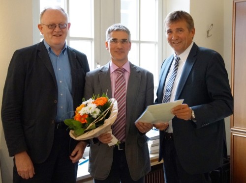 Technischer Beigeordneter Thorsten Paulussen (Mitte) erhält aus den Händen von Bürgermeis- ter Christian Liebrecht (rechts) im Beisein des Personalratsvorsitzenden Rüdiger Fuhrmann (links) die Ernennungsurkunde für seine zweite Amtszeit als Beigeordneter der Stadt Lage.