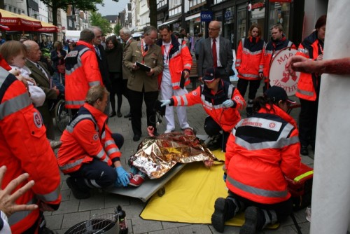 Schnelle Hilfe bei Grillunfall – Schiedsrichter und Passanten beobachten Teilnehmerteam beim Wettbewerb der Johanniter 2014 in der Detmolder Innenstadt.