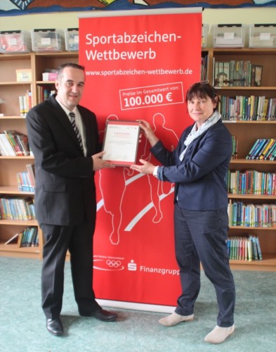 Regionalleiter Stefan Wrede überbrachte die Urkunde über die Auszeichnung mit dem Sonderpreis im Sportabzeichenwettbewerb an Martina Wolf-Sedlatschek vom Förderverein der Grundschule Lichtenau e.V.