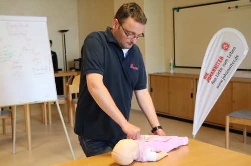 Lernen zu helfen - Björn Jockwig demonstriert Herzmassage bei einem Baby. 