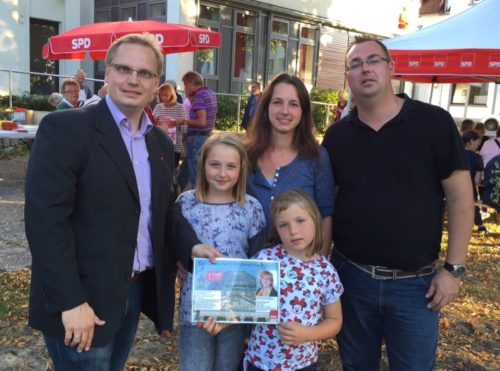 SPD-Chef Dennis Maelzer (l.) übergibt den Gutschein für eine Berlinfahrt an Emma und Charlotte Capelle. Die Eltern Corinna und Mark-André Capelle freuen sich mit.