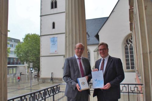 Auf dem Foto sehen Sie Bürgermeister Rainer Heller (links) mit der druckfrischen Jubiläumsausgabe der revidierten Lutherbibel und Landessuperintendent Dietmar Arends / Lippische Landeskirche nach der Urkundenübergabe im Rathaus