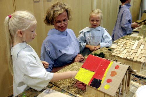 Verbandsvorsteherin Anke Peithmann unterhält sich mit Rosa (links) und Lucie über die Langhäuser, die sie gebaut haben