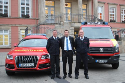 Auf dem Foto sehen Sie: Harald Lux (links) und Joachim Wolf (rechts, beide stellvertretende Leiter der Detmolder Feuerwehr) und in der Mitte Kämmerer und I. Beigeordneter Frank Hilker mit den neuen Fahrzeugen