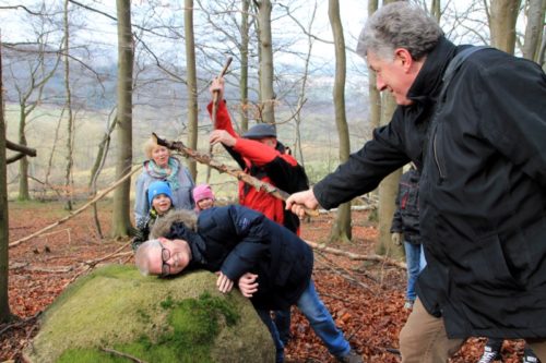 Wanderer am Opferstein. Der Kopf passt gut in die Mulde auf dem großen Findling.