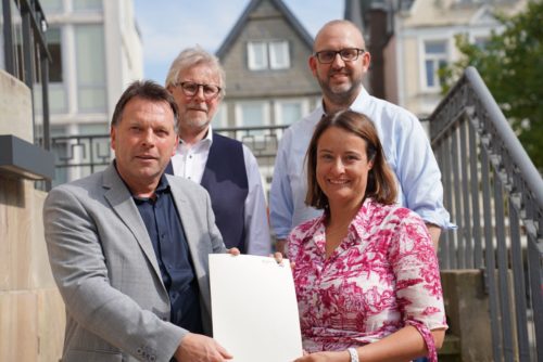 Regierungspräsidentin Anna Katharina Bölling überreicht Bürgermeister Frank Hilker den Förderbescheid. Im Hintergrund: der Technische Beigeordnete Thomas Lammering und Martin Kölczer, Leiter des Fachbereichs Stadtentwicklung (v.l.). 